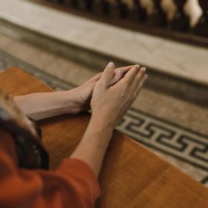 Close-up of hands in a meditative gesture against a calm background.