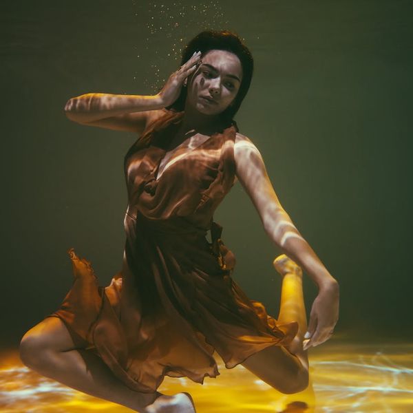 Person in a dynamic yet graceful pose, suggesting fluid motion.