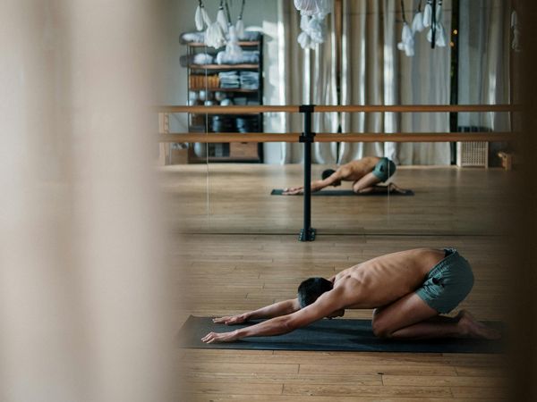 Person practicing mindful movements in a bright, minimalist studio.